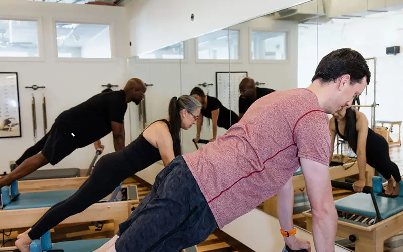 Small group Reformer Pilates class at Core and Restore Pilates near Hampton Cove Huntsville Alabama with clients using equipment in a guided session